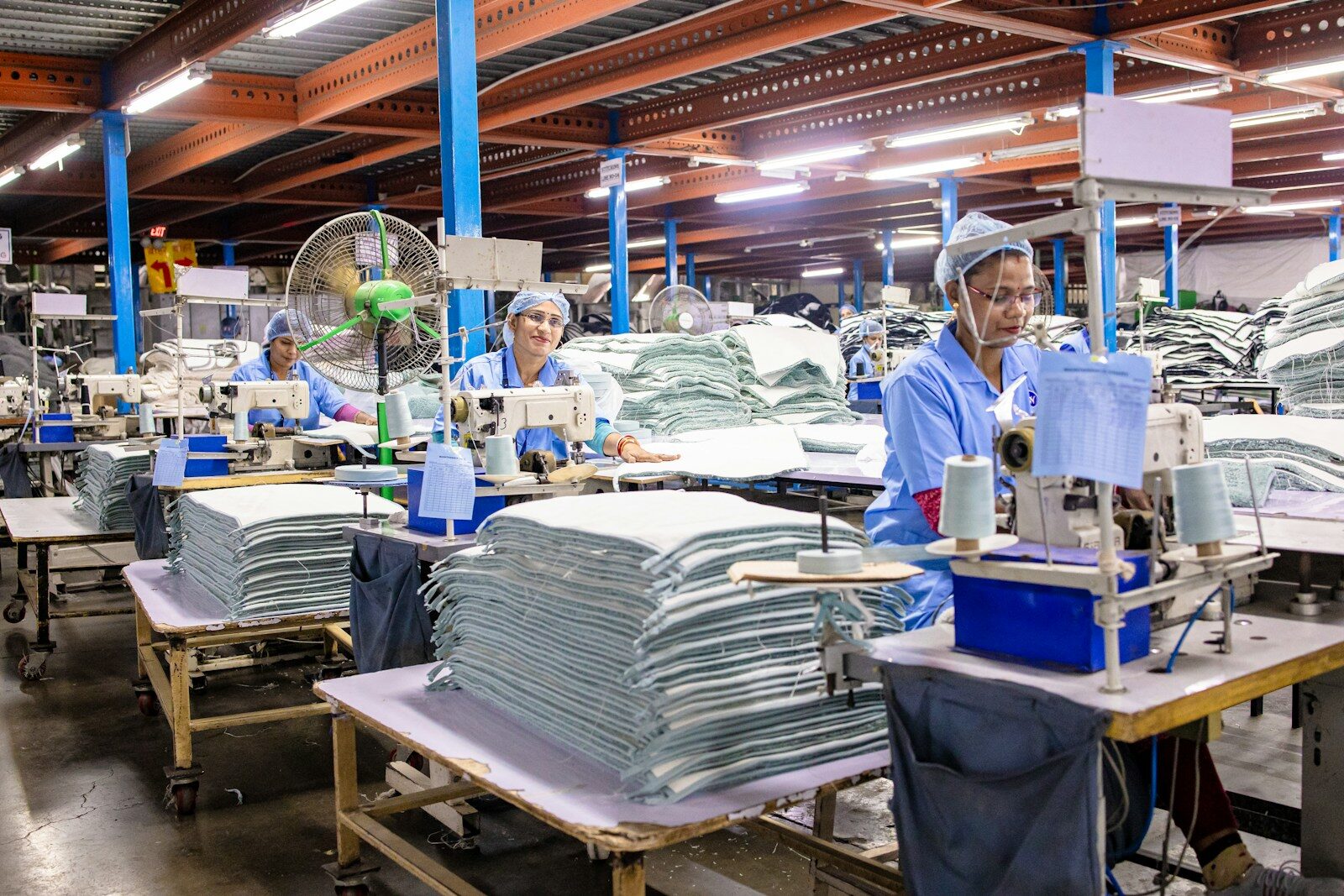Workers are sewing textiles in an industrial factory.