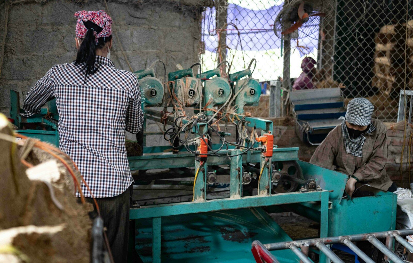 Workers operating machinery in a factory setting.